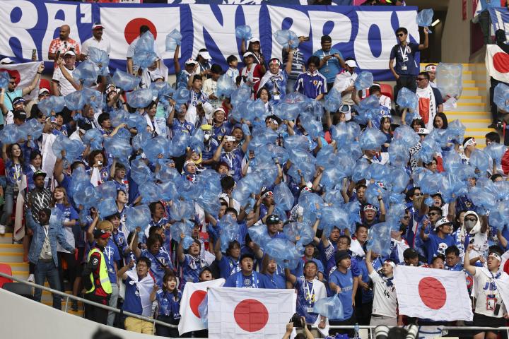 Aficionados japoneses agitan sus bolsas de basuras durante el Mundial de fútbol.