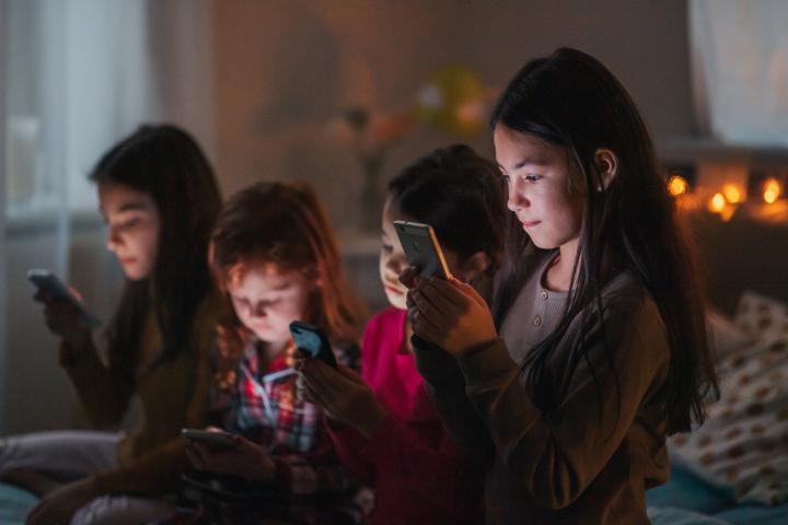 Best friends scrolling through social media during sleepover party.