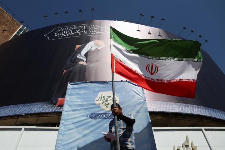 Un hombre sostiene una bandera iraní en una calle de Teherán (Irán), 15 de junio de 2026, tras el anuncio de acuerdo con EEUU.