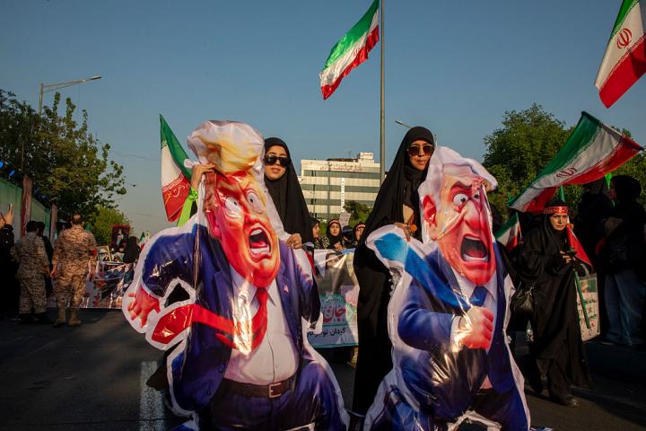 Iraníes sostienen caricaturas del presidente estadounidense Donald Trump y del primer ministro israelí Benjamin Netanyahu en el Día del Ejército, el 17 de abril de 2026 en Teherán.