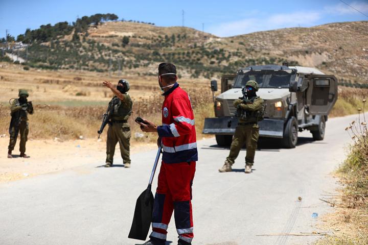 Soldados israelíes cortan una carretera junto a campos de cultivo en la Cisjordania ocupada