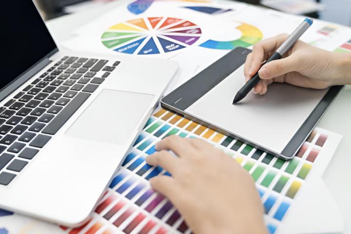 Un diseñador gráfico trabajando con colores y con un ordenador