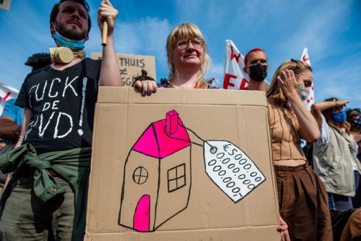 Una joven sostiene una pancarta que muestra el precio de una casa, en una manifestación por una vivienda digna en Ámsterdam (Países Bajos), el 12 de septiembre de 2021.