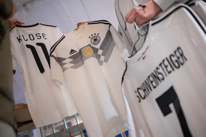 Unos consumidores compran camisetas de la selección alemana de fútbol para el Mundia en una fotografía tomada en Berlín (Alemania).
