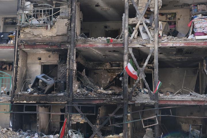 Banderas iraníes ondean en un edificio de un complejo residencial en el sureste de Teherán, gravemente dañado por un ataque de Israel y EEUU, el 5 de marzo de 2026.