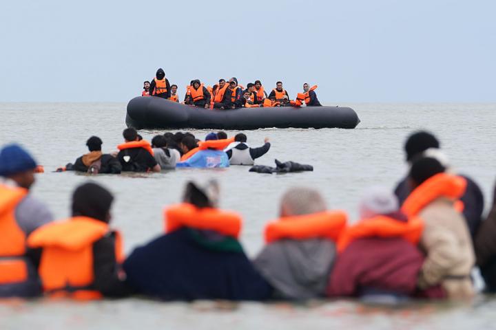 Personas migrantes bracean en el agua intentando abordar una pequeña embarcación frente a la costa de Berck (Francia), en un intento por cruzar el Canal de la Mancha, el 15 de junio de 2026.