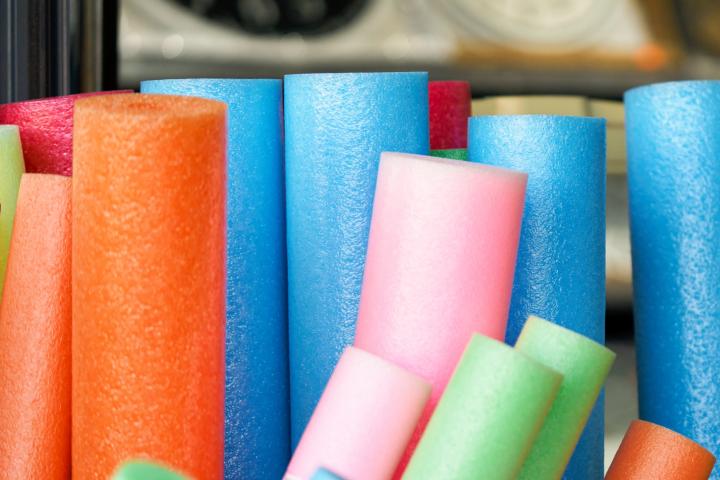 Primer plano de un conjunto de churros de piscina (cilindros de espuma flotantes) dispuestos verticalmente
