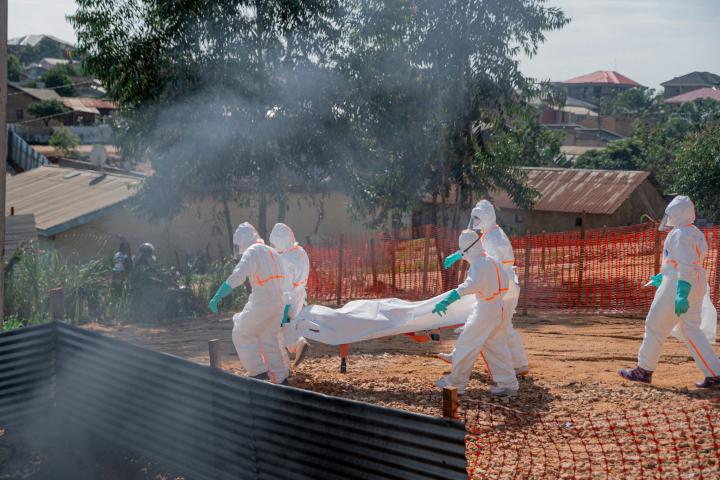 Un cuerpo es trasladado a la morgue del Centro Médico Nyankunde para los procedimientos de entierro por equipos de salud que visten trajes de protección como parte de las medidas de control de la epidemia.
