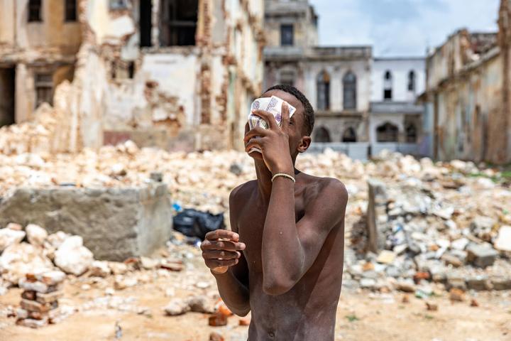 Un joven cubierto de polvo de cal y sudor sostiene billetes mientras descansa de la limpieza de escombros de un local derrumbado en La Habana (Cuba), el 11 de junio de 2026.