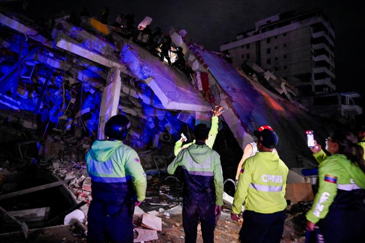 Personal de emergencia busca supervivientes entre las ruinas de un edificio derrumbado por el doble terremoto en La Guaira, Venezuela.