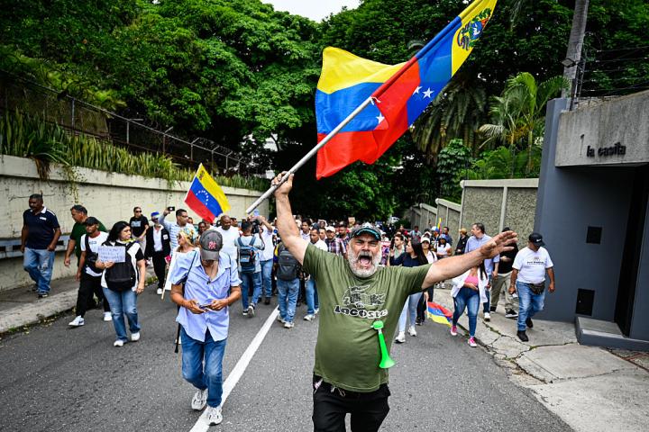 Un manifestante enarbola una bandera de Venezuela en una protesta por los servicios públicos, los salarios, las elecciones y los presos políticos, el 3 de junio de 2026, en Caracas.