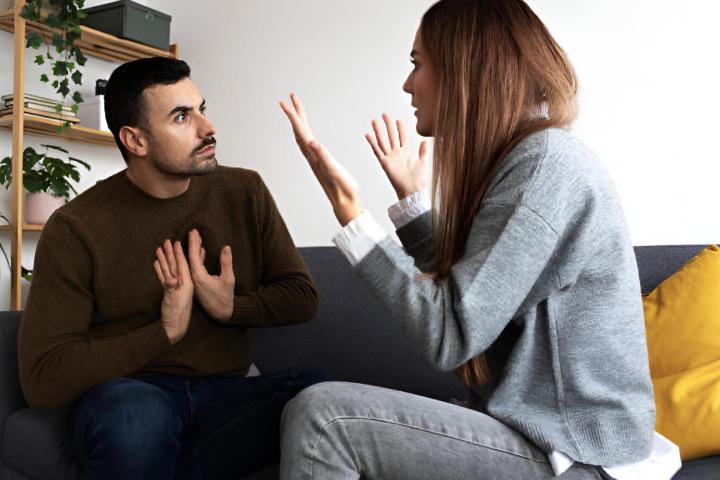 alt="alt="Una pareja discutiendo en el sofá de casa""