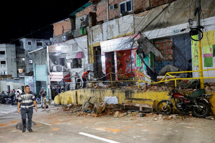 Un hombre camina junto a tiendas dañadas mientras los escombros yacen esparcidos por la calle tras el terremoto, en Caracas (Venezuela), el 24 de junio de 2026.
