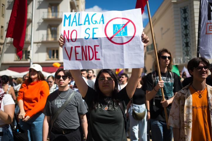 Una mujer sostiene un cartel en la manifestación de abril de 2025 en Málaga por la vivienda, en él se lee: "Málaga no se vende"