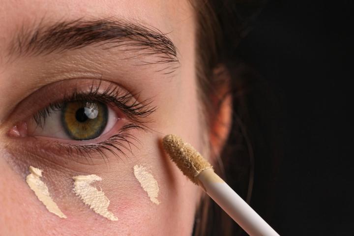 Una mujer aplicándose corrector