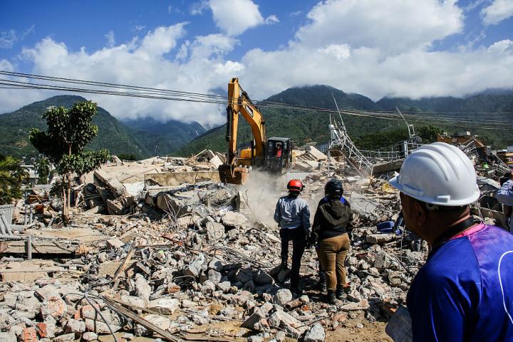 Maquinaria pesada retira los escombros de un edificio destruido por el doble terremoto en La Guaira, en Venezuela.