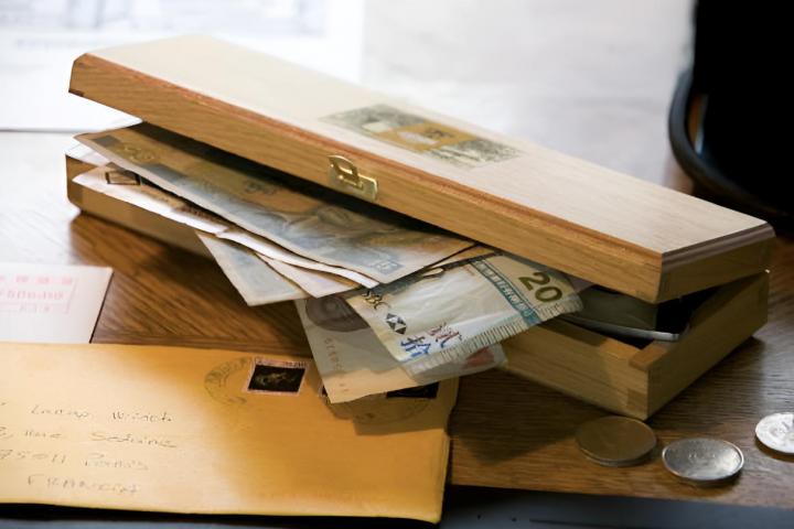 Una caja de madera llena de billetes y monedas