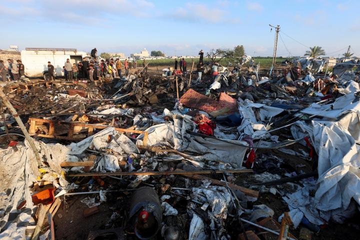Refugiados palestinos revisan el área del campamento de refugiados bombardeado por Israel en Jan Yunis (Franja de Gaza).
