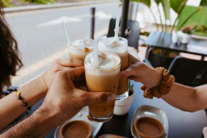 Un grupo de varias personas brindando con un café.