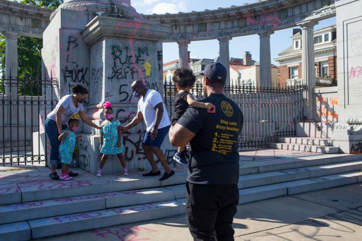 Una familia se hace fotos ante una estatua de Thomas Jefferson derribada por unos activista del movimiento Black Lives Matter, el 13 de junio de 2020, en Richmond (Virginia).