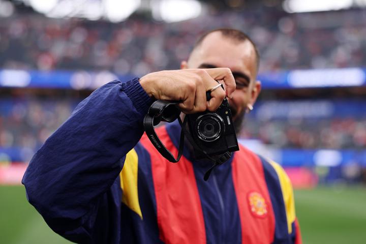 Borja Iglesias saca una cámara durante la inspección del campo antes del Austria-España.