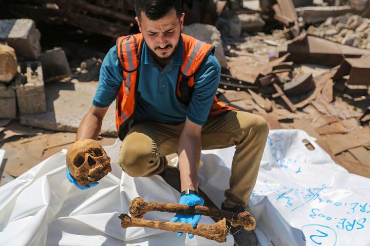 Equipos de la Defensa Civil Palestina y del Ministerio de Asuntos Religiosos realizan trabajos forenses en el cementerio de Sheikh Radwan, el 23 de junio de 2026, en Gaza ciudad.