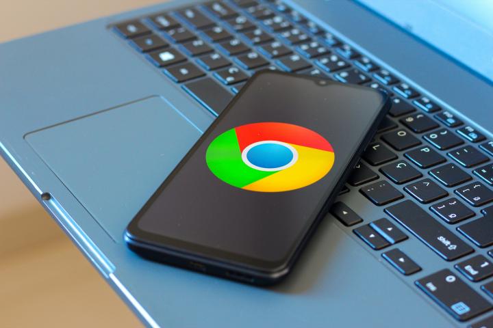 Ilustración de un teléfono móvil con el logotipo del navegador Chrome, sobre un ordenador portátil.