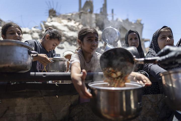 Un grupo de gazatíes, incluidos niños, hacen fila desesperados para recibir alimentos distribuidos por una organización benéfica en el campamento de refugiados de Jabalia, el 29 de junio de 2026.