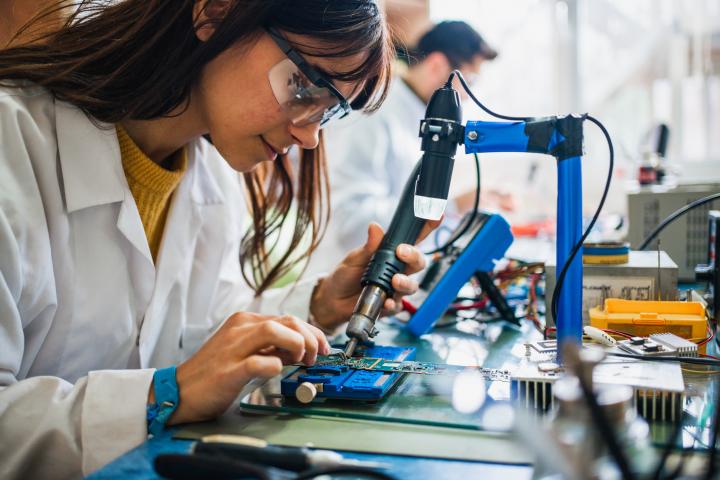 Una estudiante de FP trabajando en un panel eléctrico.