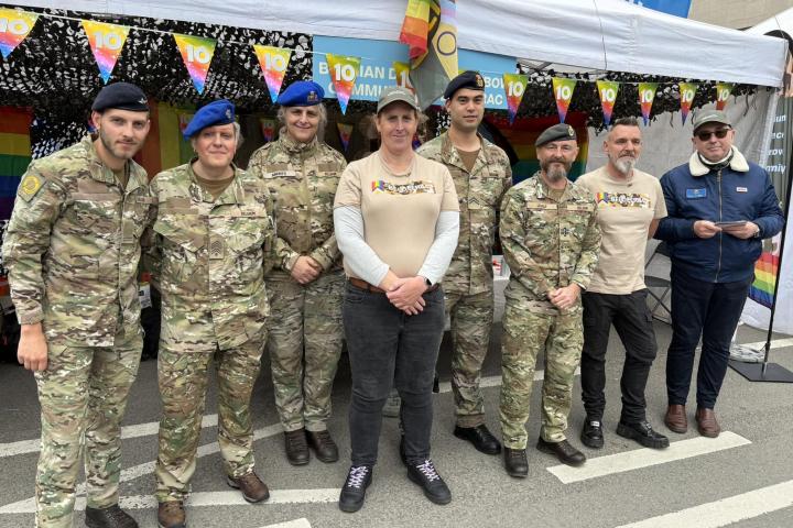 Miembros de Beldefrac (Belgian Defence Rainbow Community), el 16 de mayo de 2026, ante el stand de su organización en el Orgullo LGTBIQ+ de Bruselas (Bélgica).