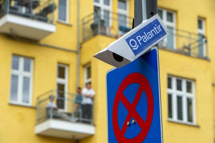 BERLIN, GERMANY - JUNE 13: A false surveillance camera with Palantir written on it attached to a lamp post at the demonstration against the police's expansion of the use of AI (artificial intelligence) powered video surveillance and analysis technology on June 13, 2026 in Berlin, Germany. Amendments to the existing ASOG (General Security and Public Order Act) were passed by the Berlin House of Representatives in December 2025. Civil liberties groups have warned that the amendments lower the thresholds for taking action against individuals and have expressed further concerns that automated facial recognition could lead to mass surveillance of the general public. (Photo by Craig Stennett/Getty Images)