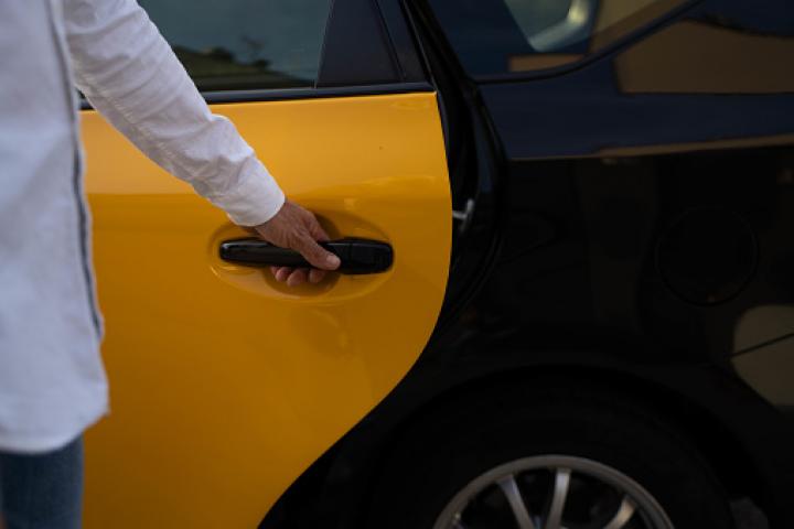 Una persona cerrando una puerta de un taxi en Barcelona.