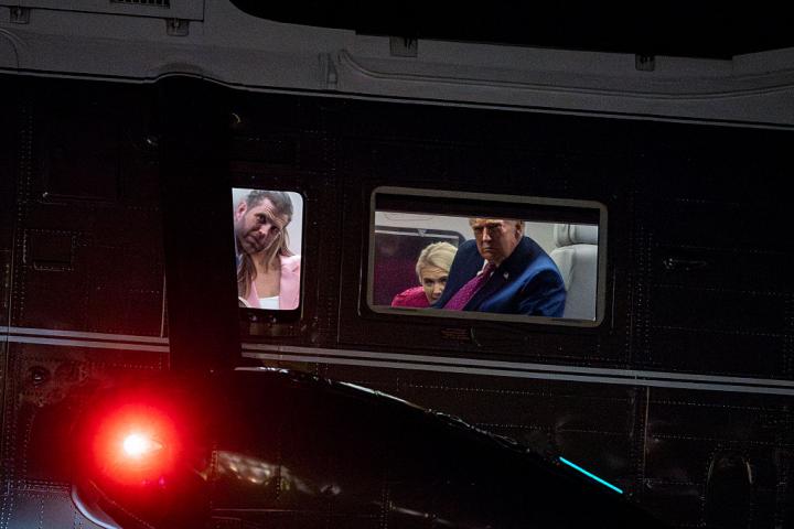 El presidente de EEUU, Donald Trump mira por la ventana de su helicóptero junto a su hijo Eric y su asesora Natalie Harp, 10 de abril de 2026 en Washington.