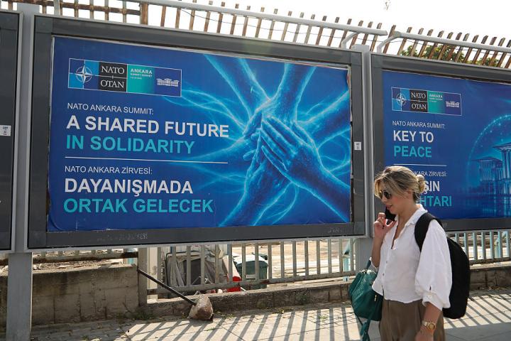 Una mujer camina ante un cartel que anuncia la Cumbre de la OTAN en Ankara, la capital de Turquía, el 5 de julio de 2026.