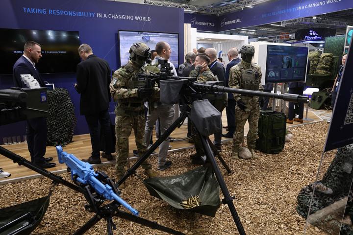Unos visitantes caminan junto a un maniquí que maneja armas de gran calibre en el stand de Rheinmetall en el Enforce Tac 2026, el 24 de febrero de 2026, en Núremberg (Alemania).