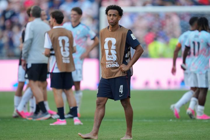 Tyler Adams, tras la eliminación de Estados Unidos. Al fondo, los jugadores belgas celebran el pase a cuartos.