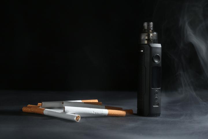 Un vaper junto a unos cigarrillos