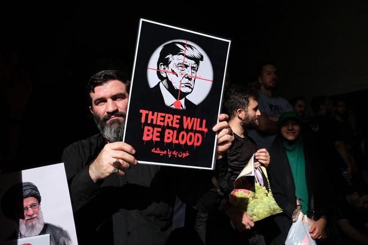 "Habrá sangre", se lee en la pancarta de un iraní, con Donald Trump en la diana, durante el funeral del líder supremo Ali Jamenei, el 5 de julio de 2026, en Teherán.