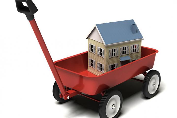 Una ilustración de una casa en una carretilla, simulando una mudanza