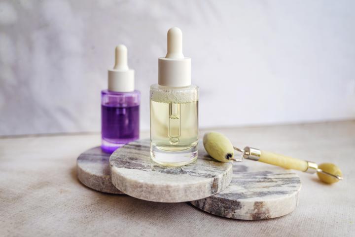 Sérum facial antiedad con bakuchiol y niacinamida sobre un fondo con sombras.