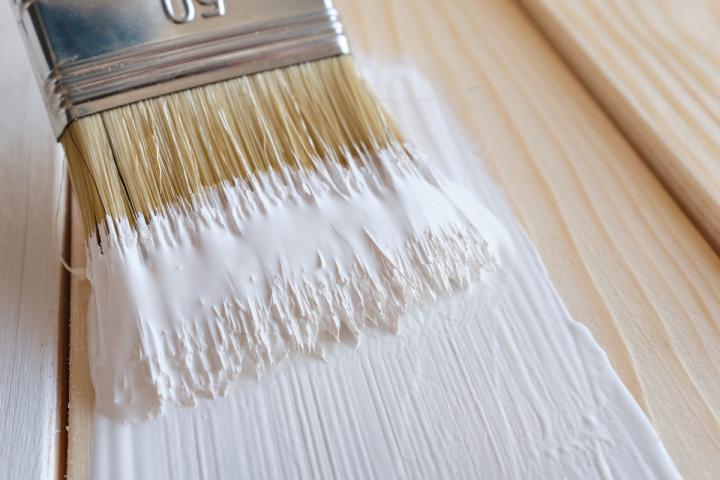 Una brocha con pintura blanca