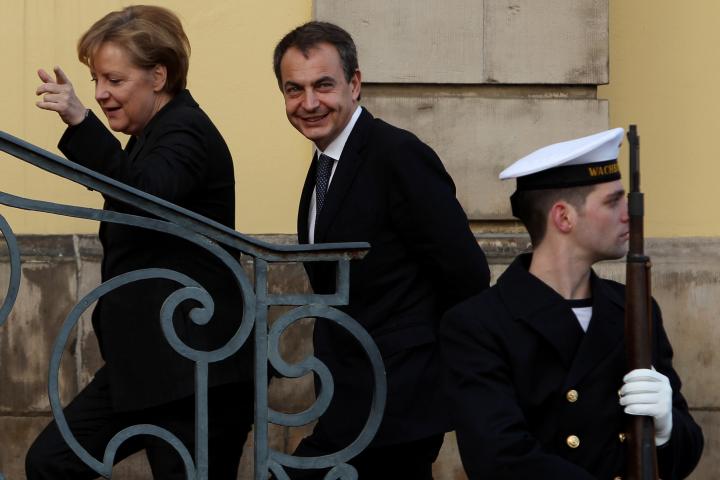 alt="alt="La entonces canciller alemana Angela Merkel sube una escalera acompañada del expresidente del Gobierno de España, José Luis Rodríguez Zapatero""