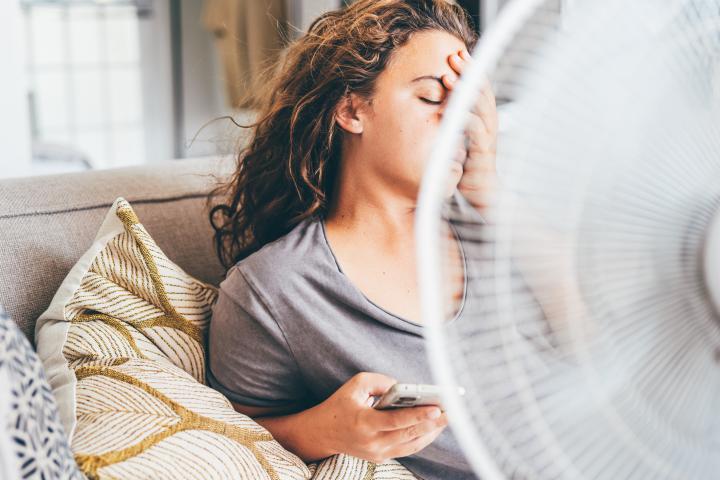 Una mujer, desesperada por el calor en una casa
