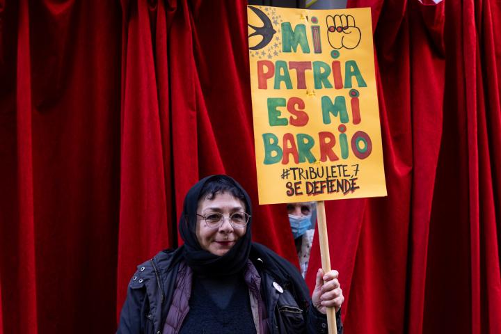 Una mujer sujeta un cartel en el que se lee "Mi patria es mi barrio, Tribulete se defiende" en una protesta contra los desahucios del bloque de Lavapiés