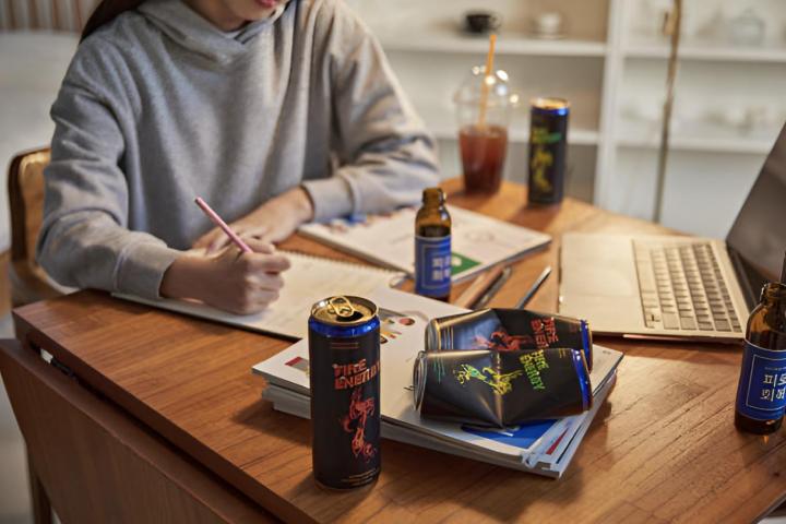 Una adolescente con bebidas energéticas mientras hace deberes frente al ordenador