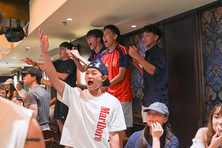 Un grupo de jóvenes chinos celebra la victoria de España en el Mundial en un bar de Hong Kong (China).