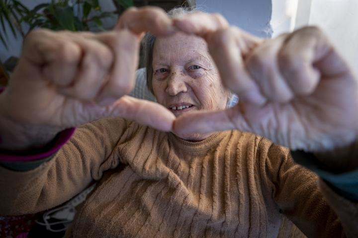 Una mujer mayor, haciendo el corazón ante la cámara en una imagen de recurso