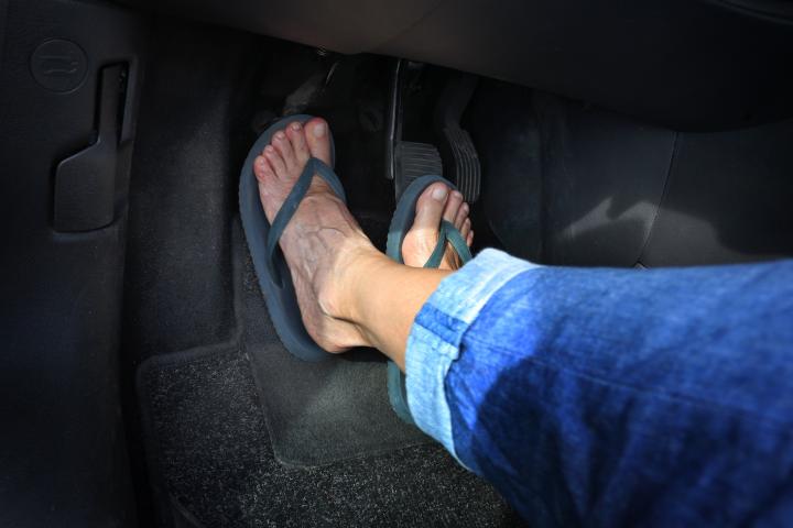 Una persona conduce con chanclas.