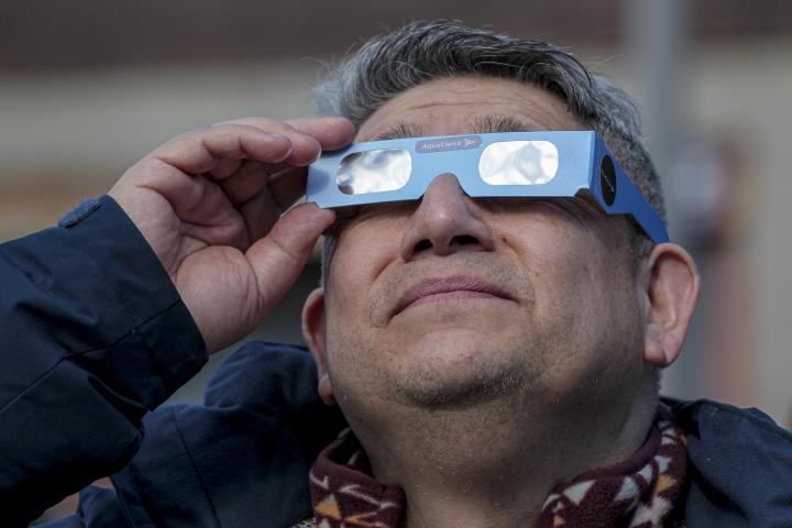 Un hombre viendo un eclipse con gafas