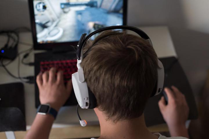 Un joven jugando videojuegos en el ordenador